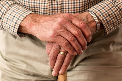 Elderly man leaning on walking stick