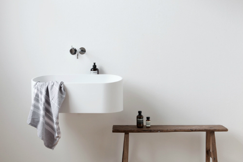 Ein minimalistischer Bad mit einem ungewöhnlichen Waschbecken aus glatten Cristalplant.