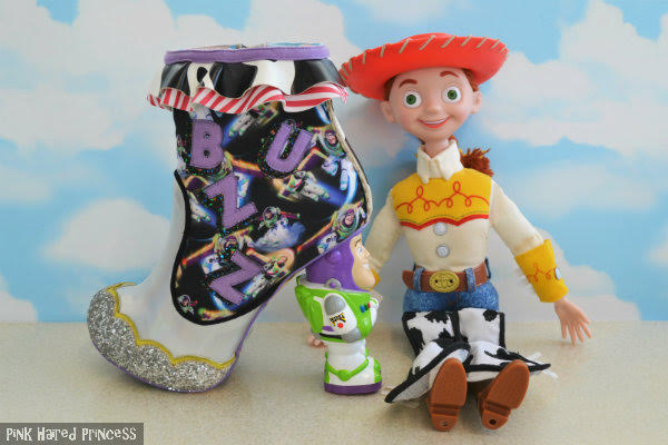 Irregular Choice You Are A Toy! Toy Story Buzz side silver buzz lightyear ankle boot sitting beside jessie cowgirl large doll and sky wallpaper background