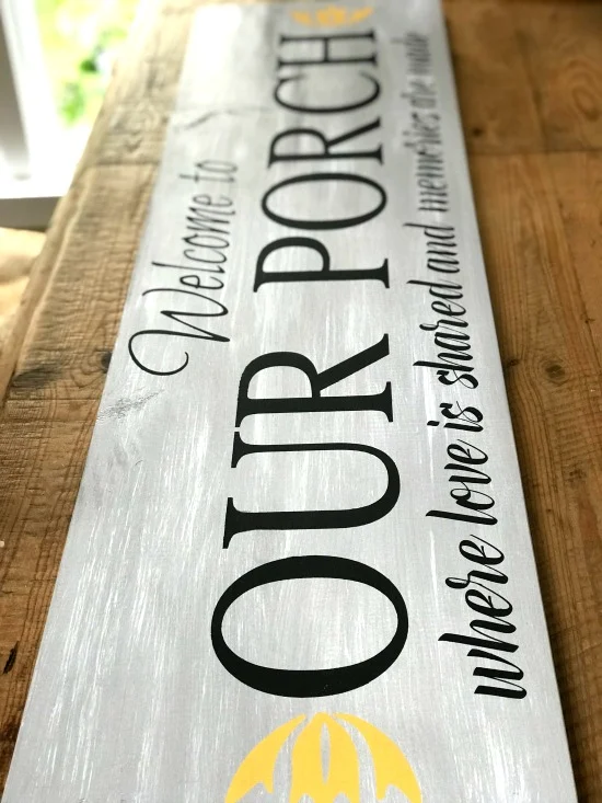 welcome to the porch sign with black writing