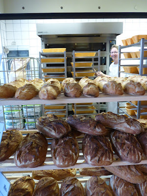 Blick durch viele Brote hindurch in Richtung Backofen