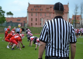A referee watch over an american football game. A referee watch over an american football game.