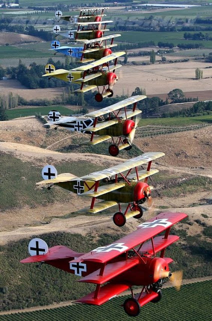 Modern photo of seven refurbished German WWI era TRI-PLANE FIGHTER BRIGADE flying in formation. Dogfights and other stories of pilots. marchmatron.com Modern photo of seven refurbished German WWI era TRI-PLANE FIGHTER BRIGADE flying in formation. Dogfights and other stories of pilots. marchmatron.com