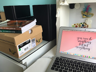 A Dr. Martens shoebox with two revision guides on top of it, next to a MacBook.