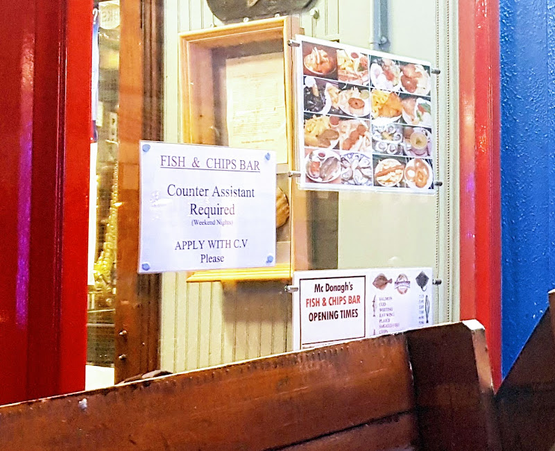 Pictorial fish-and-chip-shop menu, beside a staff-wanted sign
