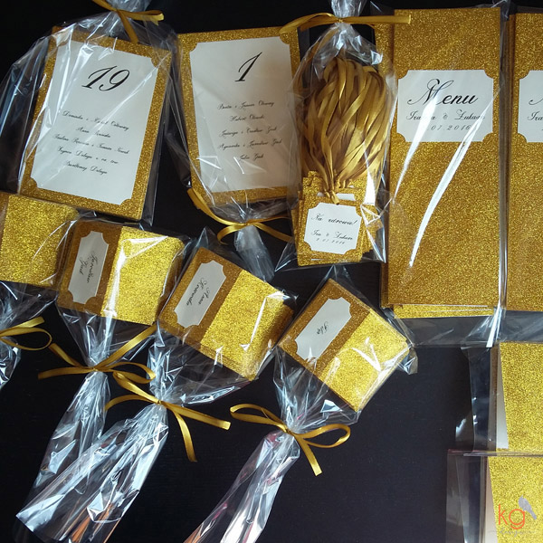 dodatki ślubne, winietki, menu, zawieszki, karteczki, plan stołów, złocone, złote dodatki, dodatki błyszczące, metaliczne, papeteria ślubna, poligrafia ślubna, dodatki na wesele, dodatki na ślub, złote wesele, złote dodatki, brokatowe dodatki, brokat na weselu, brokatowe winietki, brokatowe zawieszki, zaproszenia ślubne złote, złocone zaproszenia, złocone dodatki