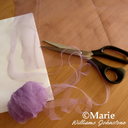 Cutting strips of tulle netting down to size for making pom poms