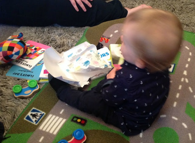 baby sat on floor with presents