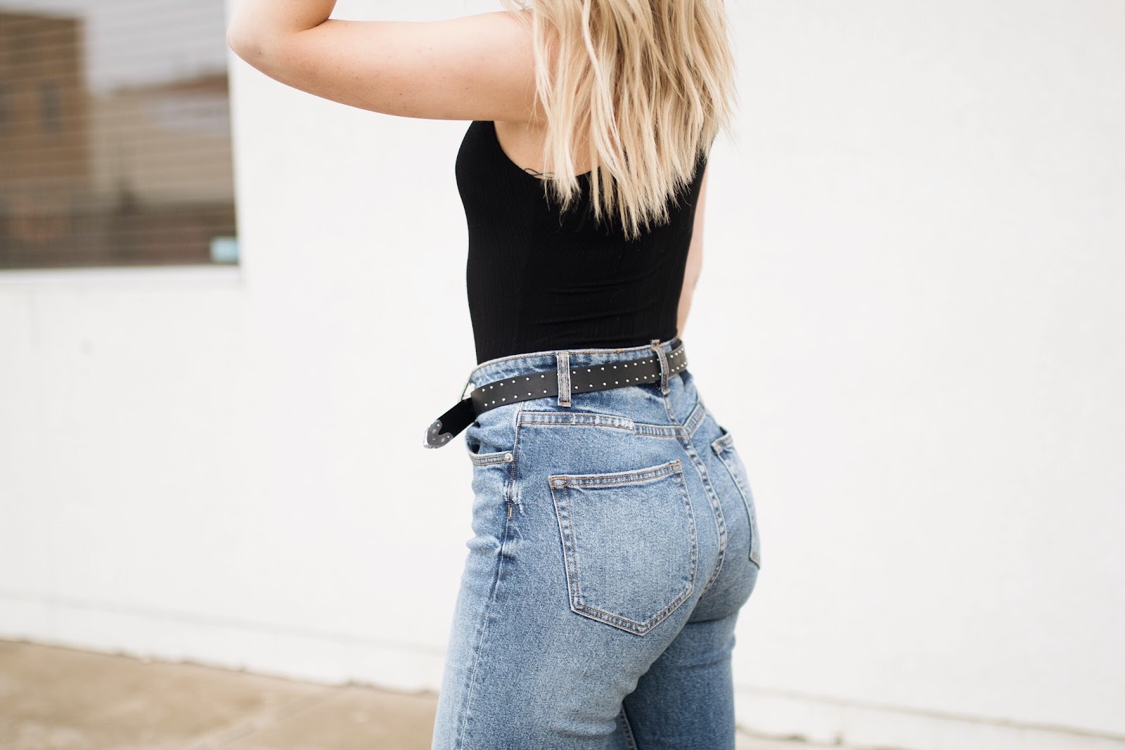 high-waisted jeans with a studded belt