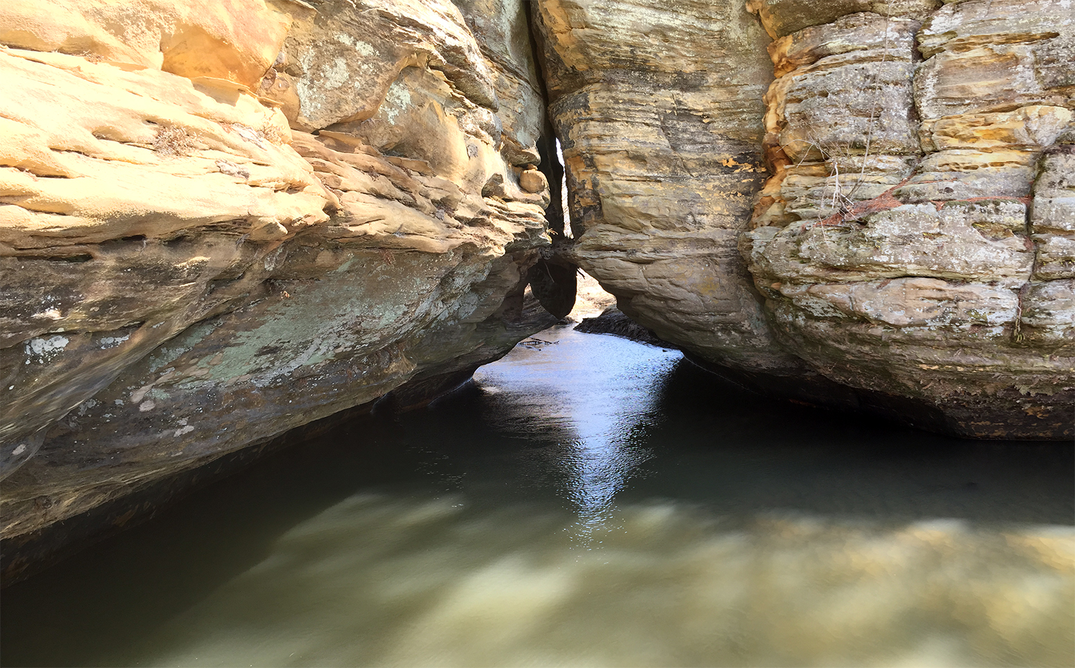 wide angle view of water flowing beneath rock reature