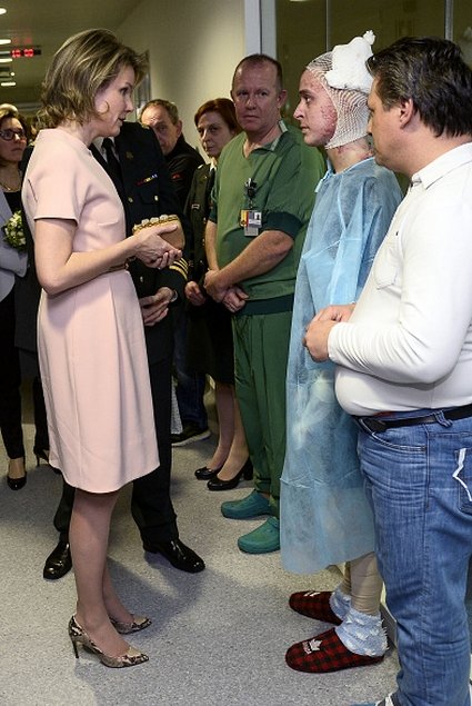 Queen Mathilde of Belgium speaks with a patient during a visit at the military hospital Koningin Astrid-Reine Astrid in Neder-over-Heembeek