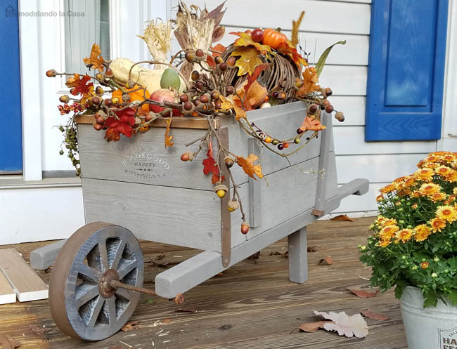 front porch decorated with rustic wheelbarrow