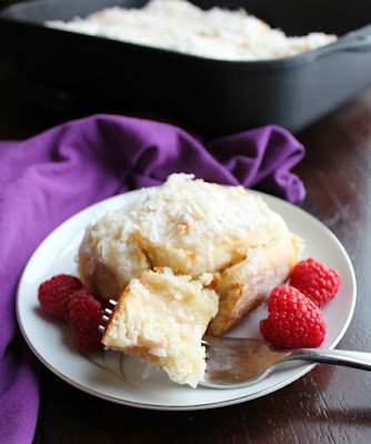Sweet coconut goodness in a cinnamon roll-like package. These sweet rolls are loaded with coconut and are the perfect breakfast or brunch treat for Easter or any day! first bite of coconut sweet roll on fork