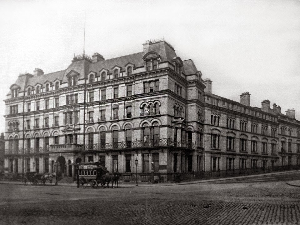 An early photo of the first Adelphi Hotel, with a horse-drawn tram in front, perhaps a cab just behind it. The streets are cobbled and empty.