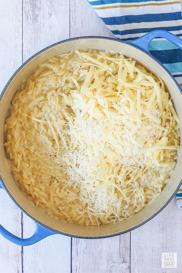 Adding cheese to orzo in pot for Cheesy Orzo dinner recipe