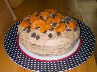 chocolate icing cake with lumps of chocolate and tangerine segments