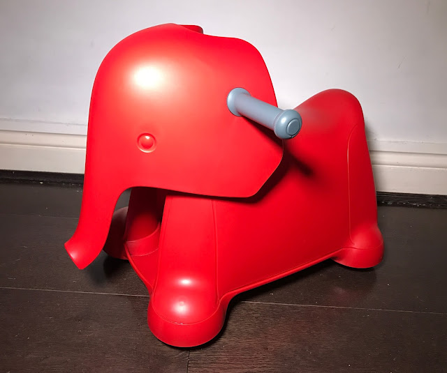 A bright red plastic stylised ride on elephant