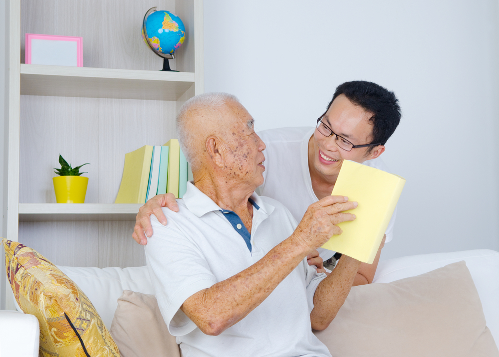 Пожилой Азиат отдыхает на кресле. Caregiver and old man Asian.