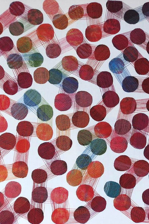 colorful stitched wool dot collage on white paper