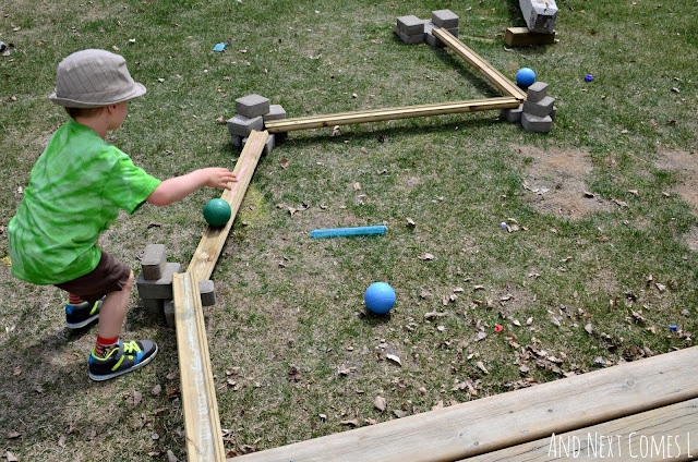 Child playing with wooden ball runs in the backyard