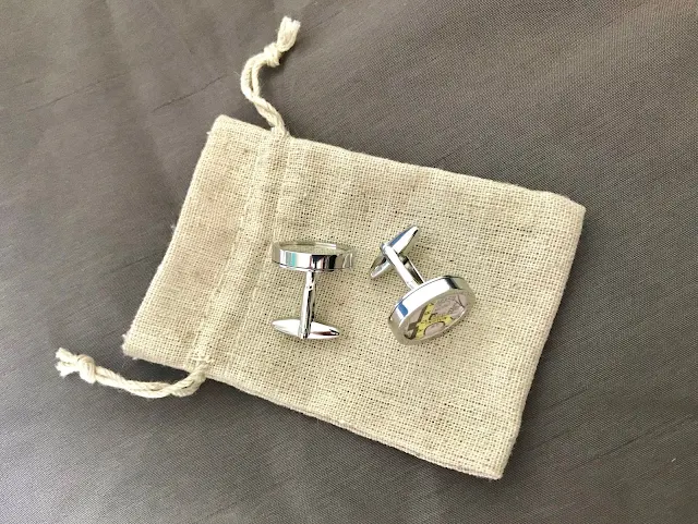 Silver personalised map cufflinks on a small fabric bag