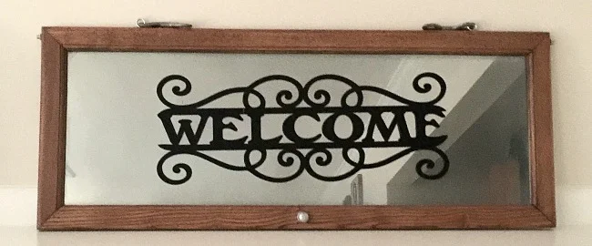 Glass cabinet door with welcome sign