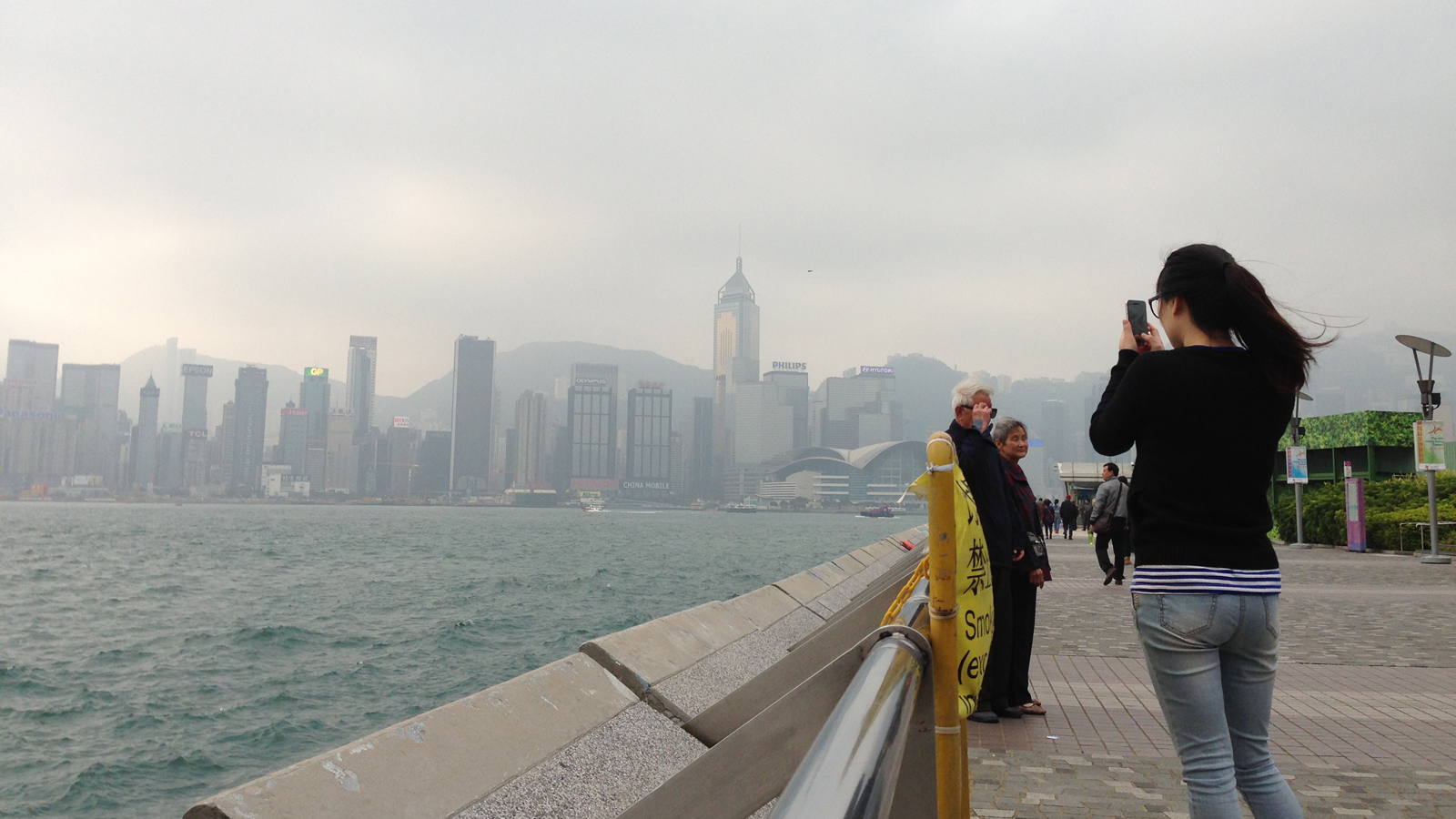 The weather may be foggy, but it hasn't stopped this woman from taking a photo of Hong Kong Island's skyline.