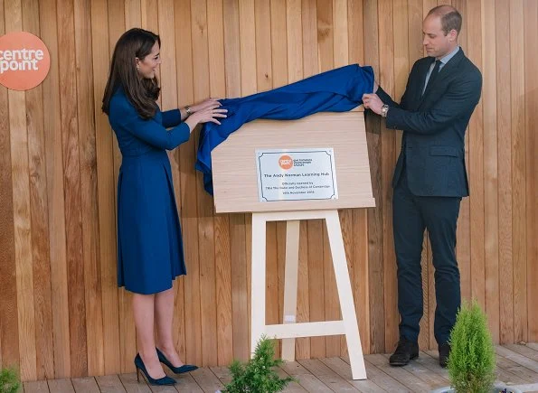 Visit to McLaren, the Duchess wore a blue dress by Eponine, and Rupert Sanderson Malory pumps, a clutch bag by Smythson