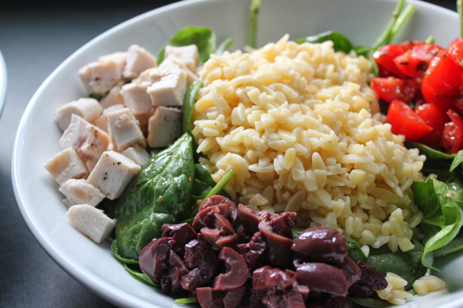 Spinach, orzo, tomatoes, olives, and chicken for Greek chicken and orzo bowls