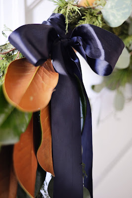 christmas garland swag on staircase with pine cedar magnolia silver dollar eucalyptus and black satin ribbon