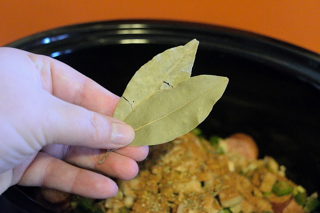 Bay leaves being added to the crockpot. 