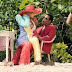 Power couple! Beyonce flaunts major cleavage in jumpsuit as she sits on Jay-Z's lap for colourful photo shoot in Jamaica (Photos)