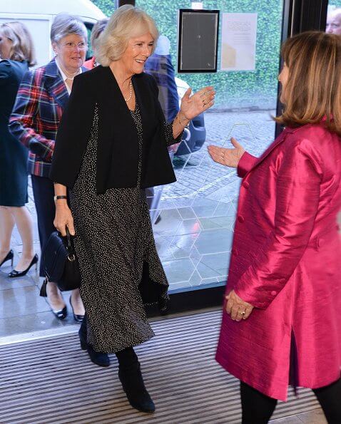 The Duchess of Cornwall sports a chic polka dot dress and ultra stylish cape at a reception for National Literacy Trust