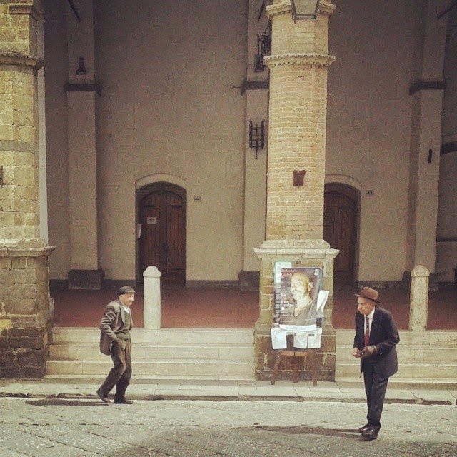 Two old and well dressed Italian men crossing Montalcino's town square