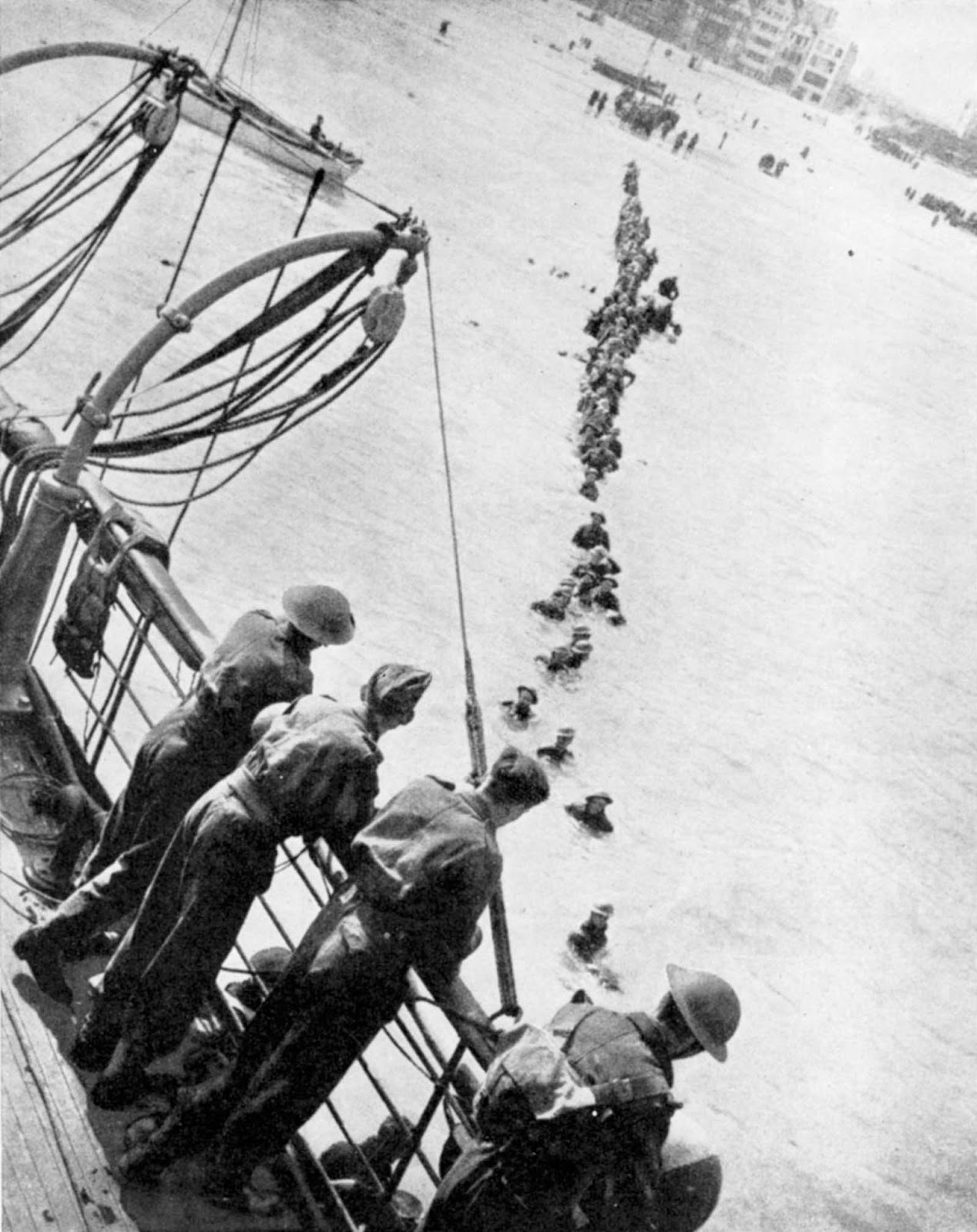 Allied troops wade to evacuation ships off the beach at Dunkirk.