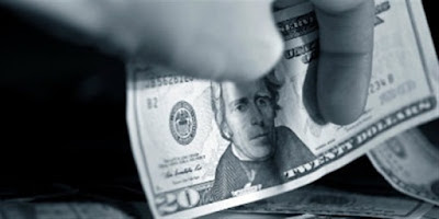 o mână care se pune să ia... o bancnotă de 20 de dolari - imagine preluată de pe christianheadlines.com o mână care se pune să ia... o bancnotă de 20 de dolari - imagine preluată de pe christianheadlines.com
