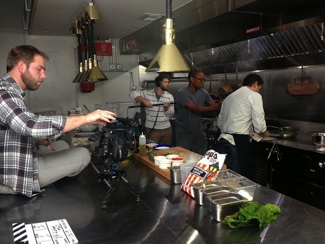 Fred Mince climbing counter tops while Jordan Lewis and Dan Jones grab some shots of Chef Jeremy Langlois in the kitchen