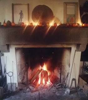 Christmas decoration for a Tuscan gathering Candles and quinces on top of the fireplace