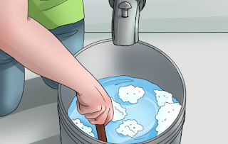 hand blending foamy water in pail 