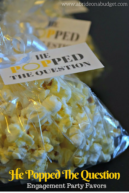 Here's a FUN and cheap engagement party favor. Use popcorn and make these He Popped The Question Engagement Party Favors from www.abrideonnabudget.com. Even better, you can get the printable tag for FREE in the blog post!