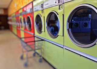 a wall of washing machines in a laundromat