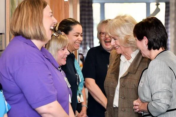 Camilla arrived at the hospice in a smart brown tweed two-piece, pairing the outfit with a simple cream blouse with over-the-knee boots