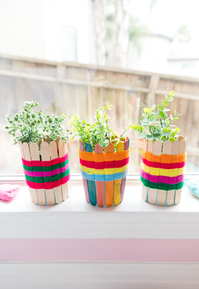 Use popsicle sticks and yarn to make these pretty woven baskets. Such a fun kids craft! #yarncrafts #kidscrafts #popsiclestickcrafts #popsiclestickweaving #kidsweaving