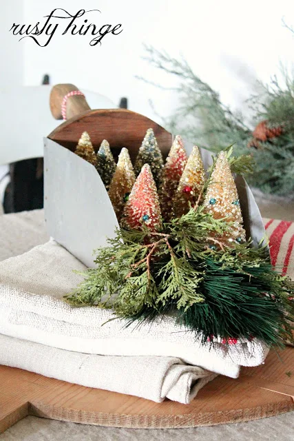 Christmas bottle trees in a scoop for centrepiece by Rusty Hinge featured at I Love That Junk #12daysofchristmas