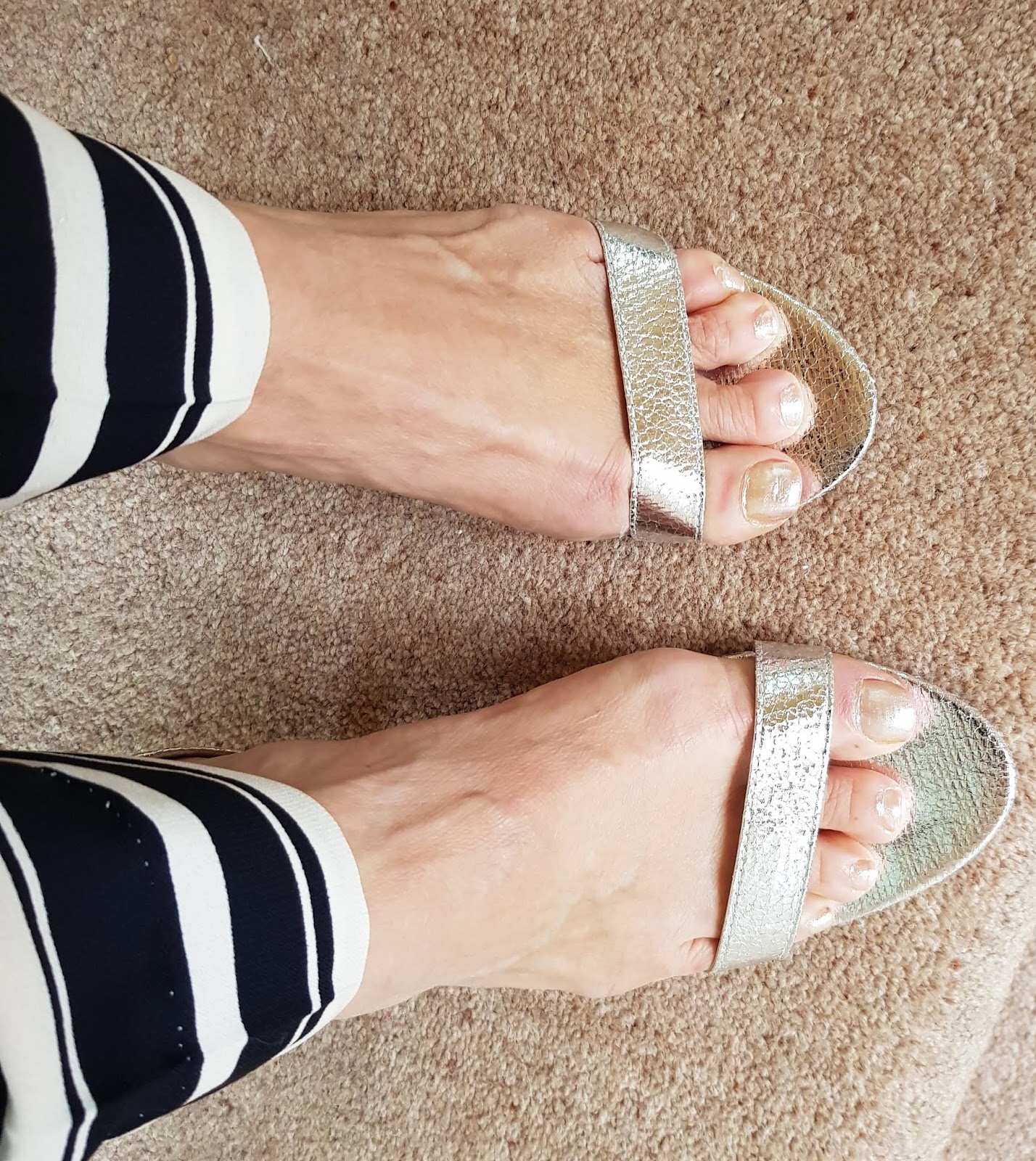 Close up of silver thin strapped naked sandals