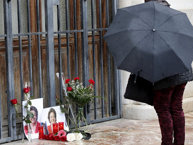Una persona se para ante unas fotografías y flores colocadas por personas anónimas en uno de las puertas del Ayuntamiento de Valencia en memoria de Rita Barberá. Agencia Efe. María Rita Barberá Nolla.