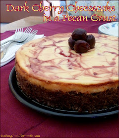 Dark Cherry Cheesecake in a Pecan Crust starts with a pecan crust as a great compliment to this classic cheesecake swirled with syrup, then topped with dark sweet cherries. | Recipe developed by www.BakingInATornado.com | #recipe #dessert