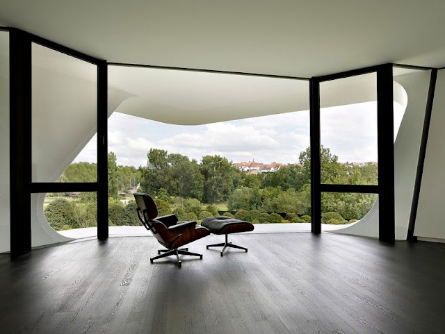 Brown Soft Chair and Big Window Wall which is Made from Glass Material