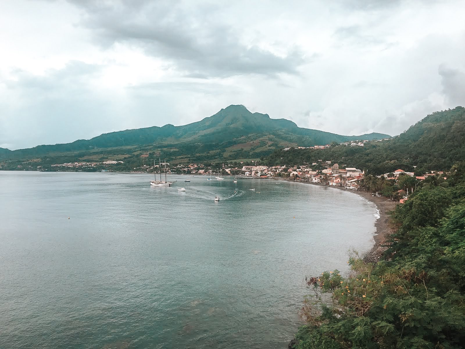 La montagne pelée en Martinique en arrière plan qui surplombe la commune de saint-pierre et des bateaux au premier plan