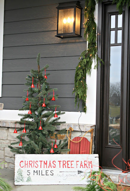 Christmas tree on porch with red bells